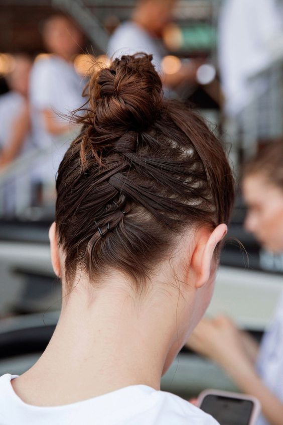 a top knot with hair secured up with bobby pins is a cool way to rock this haristyle with short hair