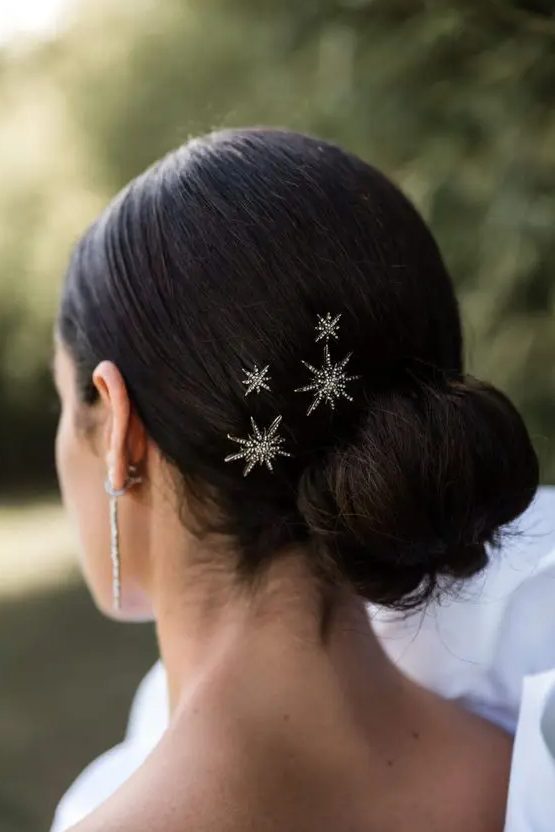 a twisted low bun with a sleek yet voluminous top and celestial hair pins is amazing to rock