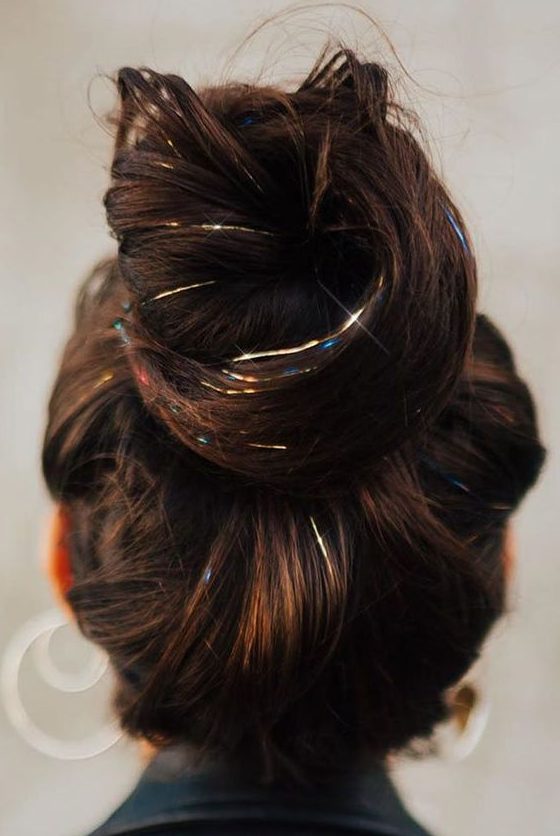 a volumetric top knot accented with colorful tinsel is a catchy and creative idea for the holidays
