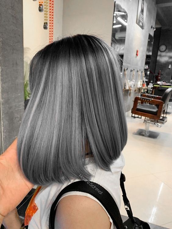 An elegant black long bob with grey balayage and a fringe looks cute and super cool and up to date