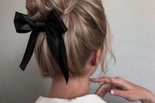 an elegant top knot with some volume on top and a black ribbon bow is a chic and catchy idea for the holidays