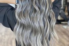 long and volumetric dark hair with grey balayage and highlights to make natural grey hair look very chic