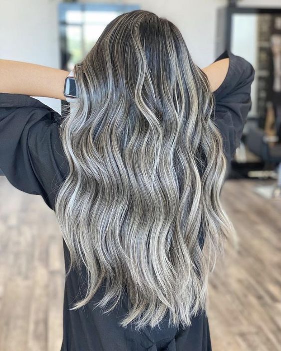 long and volumetric dark hair with grey balayage and highlights to make natural grey hair look very chic