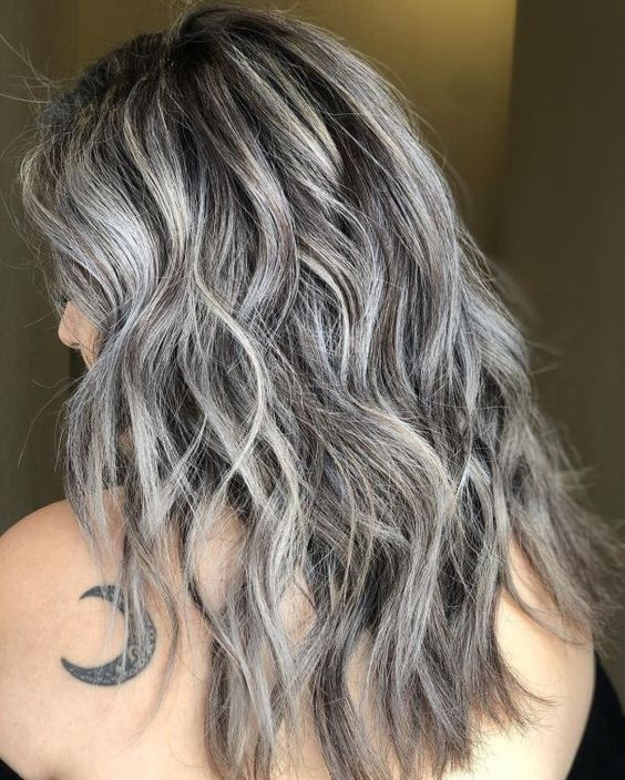 long dark brown wavy hair with silver balayage and a lot of volume is a cool and catchy idea to rock