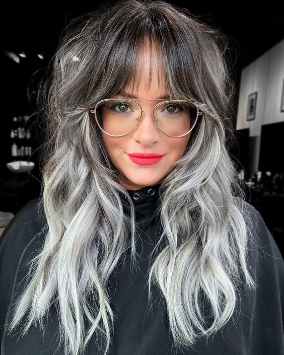 long dark hair with grey highlights and grey ombre, with layers and a wispy fringe is a lovely way to rock your greys