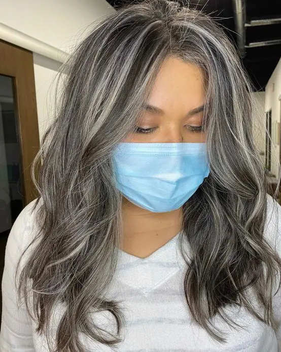 long dark volumetric hair with some grey highlights and waves is a catchy and stylish way to embrace your greys