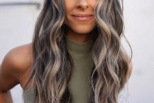 long wavy dark hair with greys naturally blended in and with a grey money piece is a catchy and cool idea