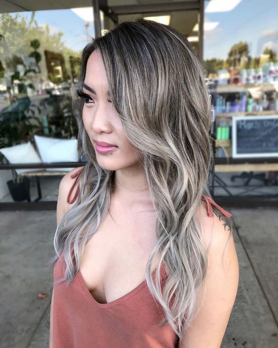 long wavy hair with grey highlights and waves is a catchy and stylish idea to rock your natural greys