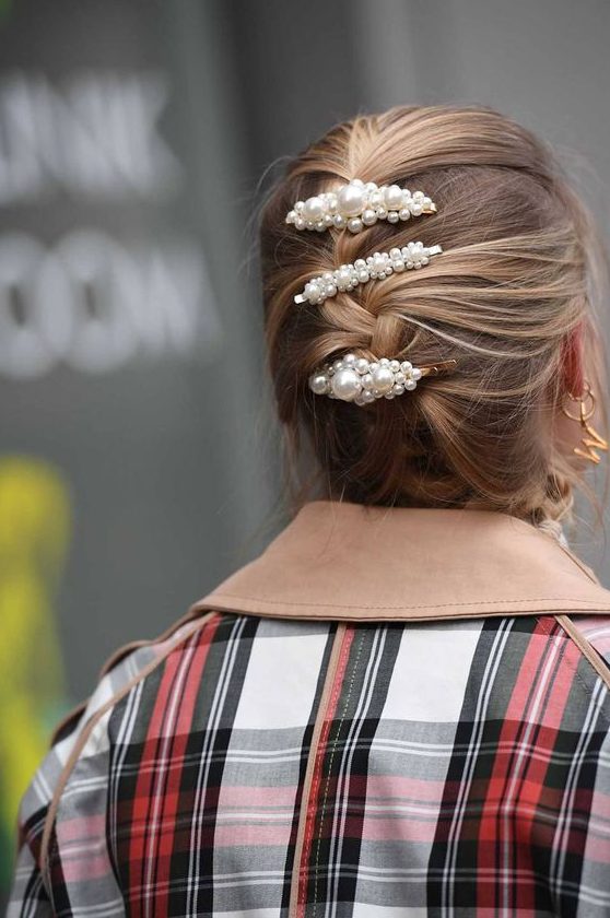 medium hair styled into a messy braided updo and accented with three matching pearl barrettes is a stylish idea