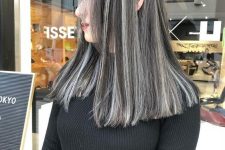 medium-length black hair with silver grey balayage and a lot of volume is a super eye-catchy and chic idea