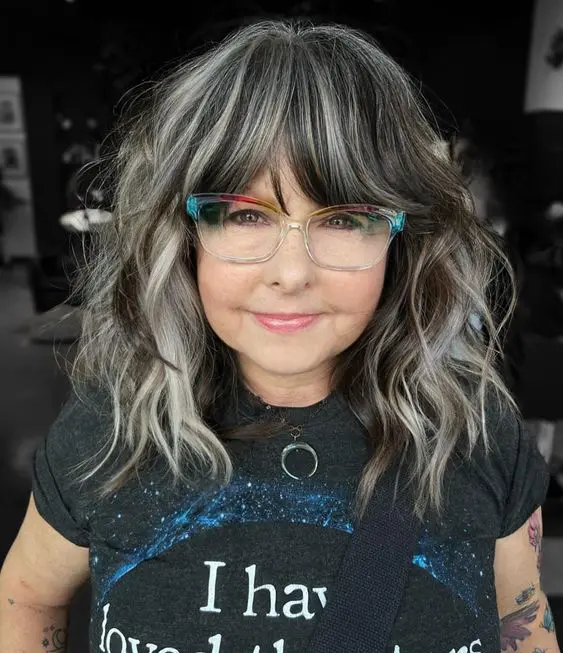 Medium length black hair with silver grey balayage and bottlneck bengs with balayage, too, with waves and volume