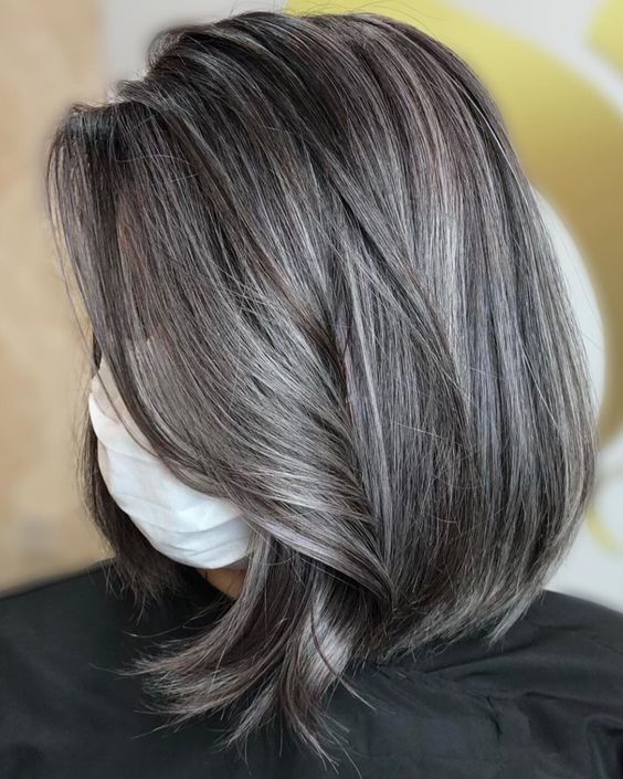 medium-length black hair with transitioning grey balayage and a bit of volume is a chic and catchy idea to rock