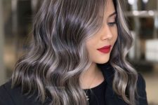 medium-length black wavy hair with beautiful and shiny grey hair blended in and a grey money piece is amazing