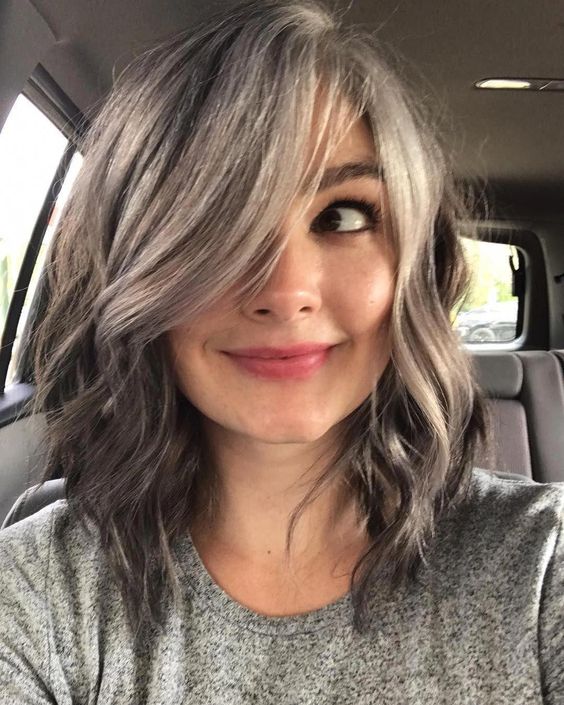 medium length layered hair with grey highlights and a money piece is a cool and catchy idea for a bold look