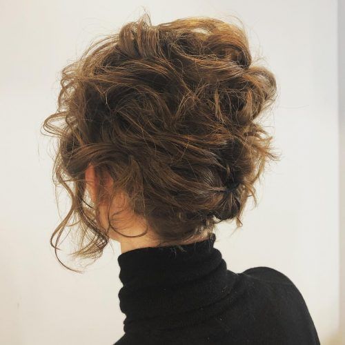 naturally wavy short hair styled as an updo secured with some pins with a wavy top and face framing hair