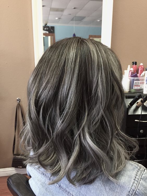 Shoulder length black hair with silver balayage and waves looks very natural, chic and beautiful