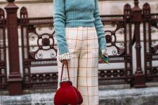 07 a bold take on preppy style with white windowpane pants, a printed shirt, a green cropped sweater, a red bag