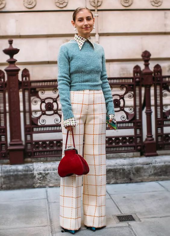 a bold take on preppy style with white windowpane pants, a printed shirt, a green cropped sweater, a red bag