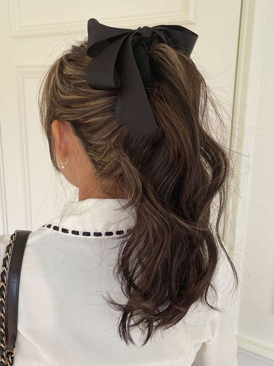 accenting your high ponytail with a black silk bow will instantly give it a chic and refined retro girlish look