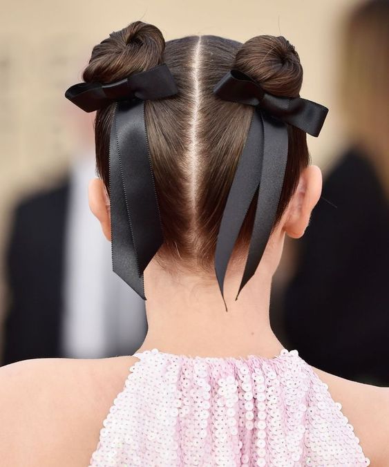 space buns accented with black silk bows are a super cool and super stylish hairstyle for a special occasion