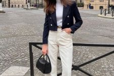 16 an old money outfit with a white turtleneck, creamy jeans, a navy cropped blazer, black shoes and a black bag