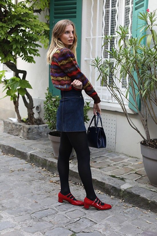 a bold look with a patterned jumper, a navy denim mini, black tights, red shoes and a black bag