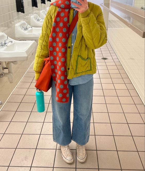 a bright outfit with a chambray shirt, wideleg jeans, a mustard jacket, a red printed scarf and an orange bag