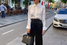 32 a classic corporate core look with a white silk button down, black wilk pants, black and white shoes and a black bag