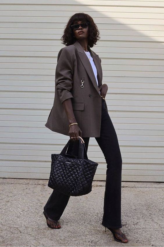 Black flare jeans, a white t shirt, a taupe oversized blazer, black shoes and a black bag
