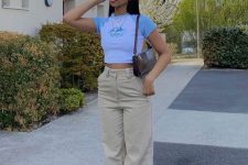 52 a 90s inspired look with a color block cropped tee, tan high waisted pants, white trainers and a baguette bag