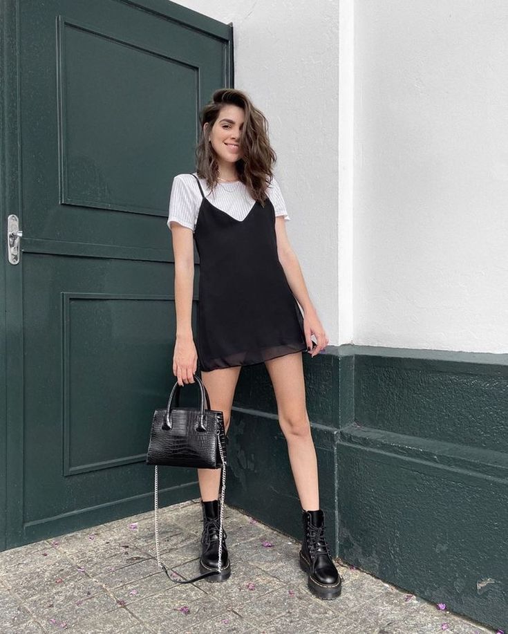 A 90s inspired look with a white t shirt, a black slip mini dress, black chunky boots and a black bag
