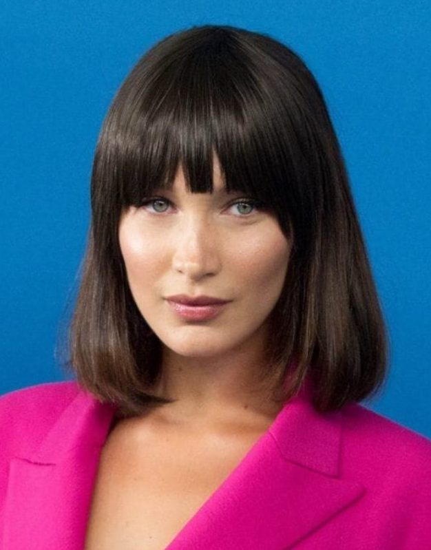 Bella Hadid wearing a dark brown bob with bangs inspired by an iconic hairstyle of Michelle Pfeiffer
