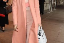 Jessica Albra wearing a blush and peach outfit with a tan top, blush pants, a Peach Fuzz coat, platform shoes and a white bag