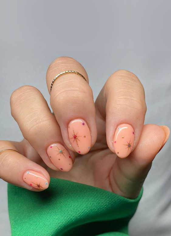 Peach Fuzz nails with colorful polka dots and stars are a unique and catchy way to rock the color of the year