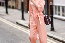 a Peach Fuzz jumpsuit with white boots, blue socks and a printed bag are a cool look for spring
