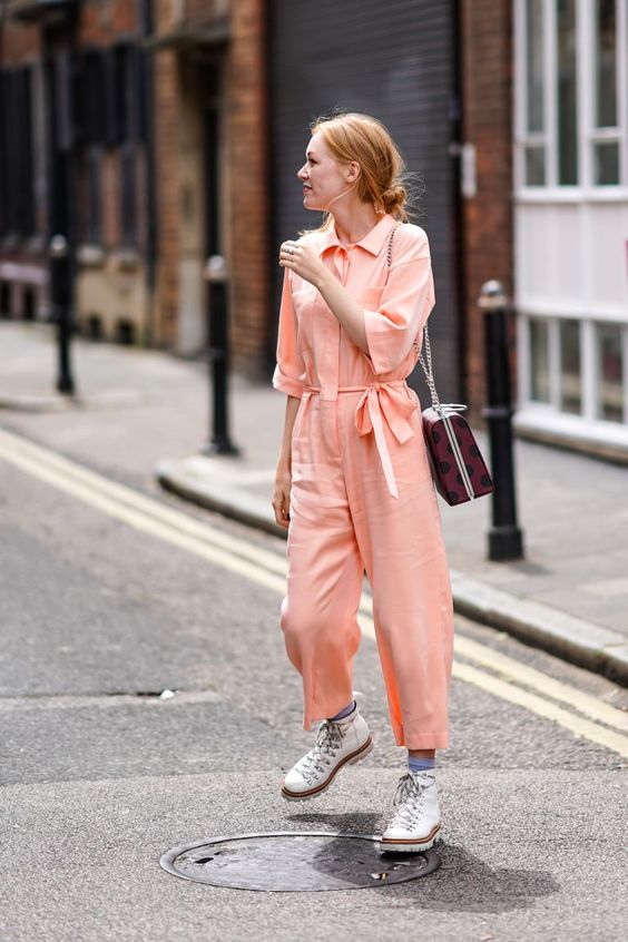 a Peach Fuzz jumpsuit with white boots, blue socks and a printed bag are a cool look for spring