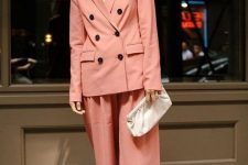 a Peach Fuzz pantsuit with culottes, a blazer with black buttons, a neutral top, white shoes and a white clutch