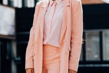 a Peach Fuzz thin stripe suit with shorts, a blush shirt and a saddle bag are a cool combo for a bold look