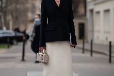 a black blazer, a creamy satin maxu skirt, black bow shoes and a statement necklace for a quiet luxury look