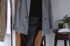 a black sweater, a slip maxi skirt, black square toe boots, a grey blazer and a black bag compose a quiet luxury look