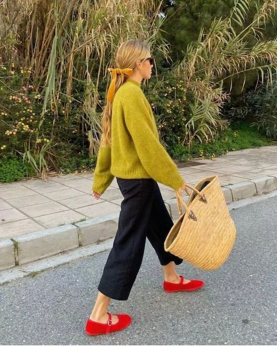 a bold fall look with a mustard sweater, black trousers, red Mary jane shoes and a woven tote