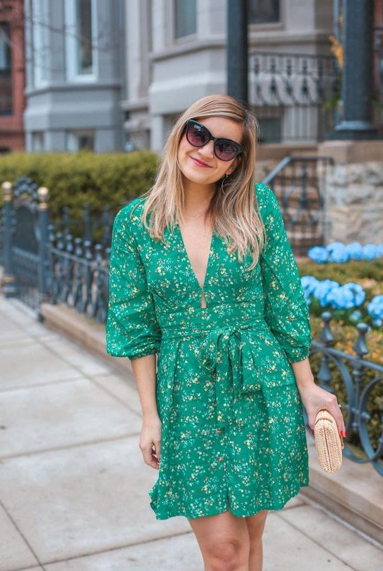 a bright green short dress with a floral print, long sleeves, a plunging neckline and a wicker clutch
