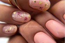 a catchy summer manicure with зуфсрн and blush nails, blush ones accented with colorful dried blooms and gold leaf