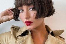 a chic dark brunette ear-length bob with a classic fringe and messy waves looks relaxed, cute and refined