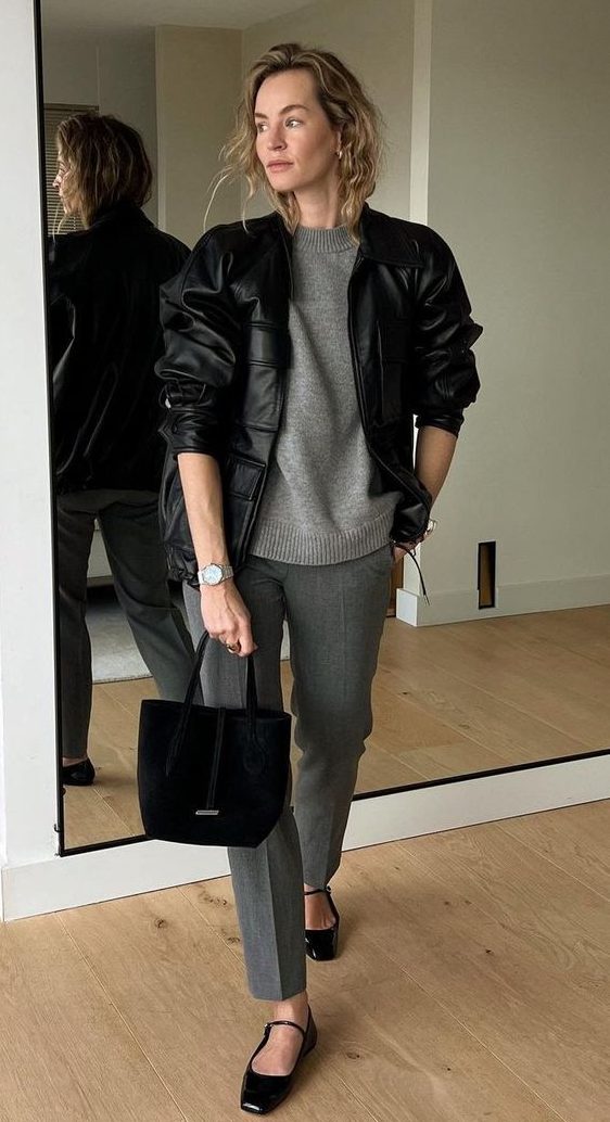 a chic work outfit with a grey jumper and pants, black mary Jane shoes, a black leather bomber, a bag