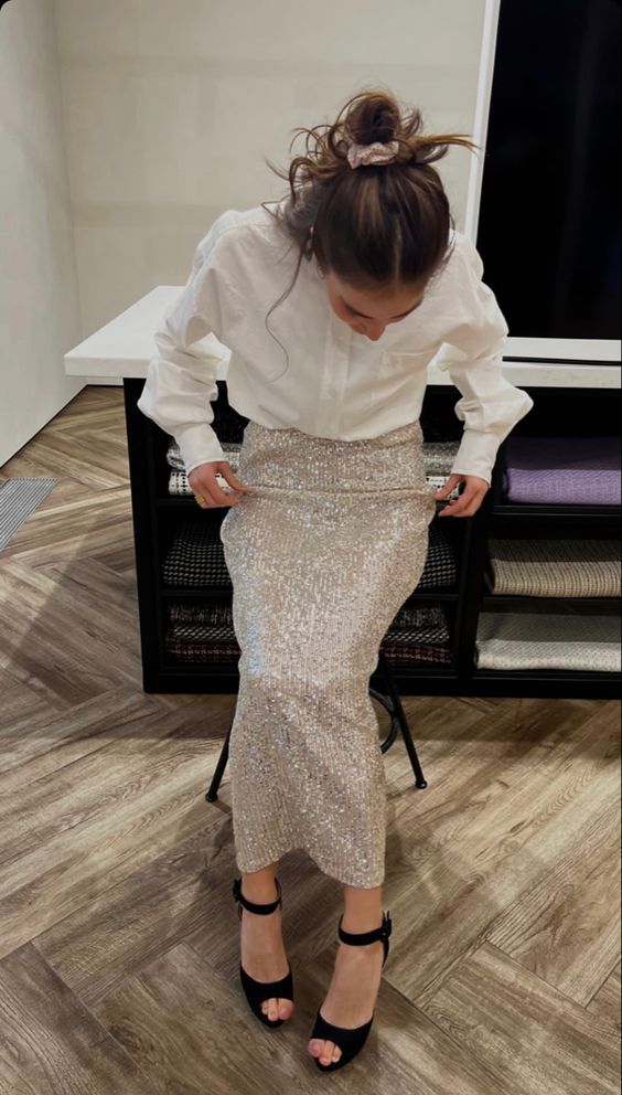A classy pre wedding party outfit with a white button down, a silver sequin maxi skirt, black shoes and a messy hairstyle