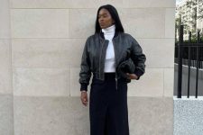 a comfy and contrasting look with a white turtleneck, a black midi skirt, a black leather bomber, black Mary Jane shoes