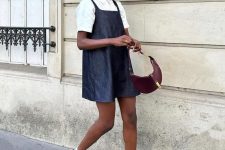 a cute look with a white polo shirt, a black dress over it, white socks, black shoes and a burgundy mini bag