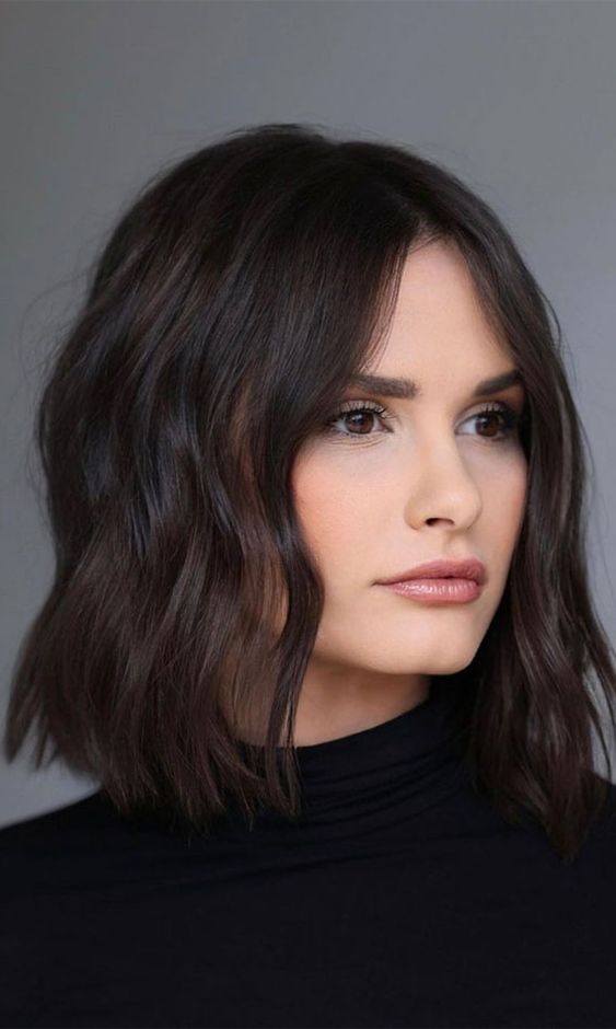 a dark brown, almost black, long bob with waves and volume, is a catchy and cool idea to rock right now