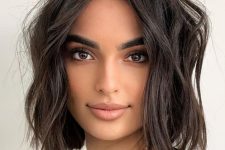 a dark brown messy wavy lob with a lot of volume is a cool and catchy idea that looks chic